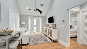 Ein modernes Wohnzimmer mit Essbereich, Fernseher und einer Treppe, die zu einem anderen Raum führt.