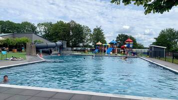 Una piscina amb tobogan i jocs infantils.