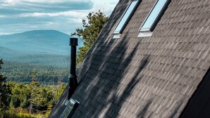 Una casa moderna con techo inclinado, tragaluces y chimenea.