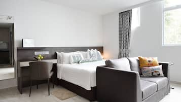Una camera da letto moderna con un letto, una scrivania e un divano.
