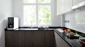 Una cocina moderna con estufa integrada, un lavamanos y ventana con vistas a la vegetación.