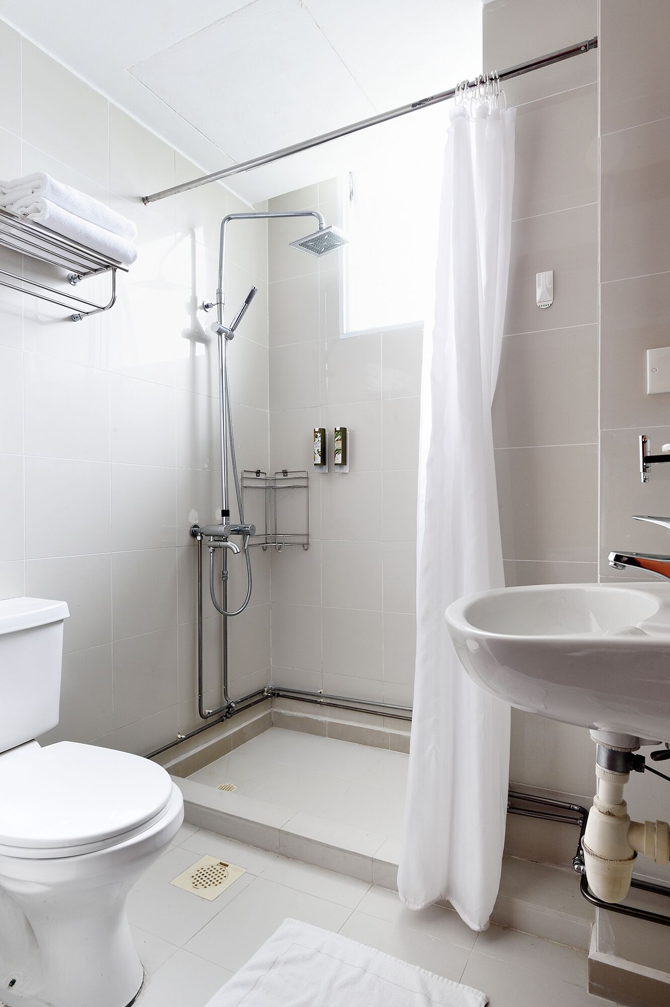 A modern bathroom with a shower, toilet, and sink.