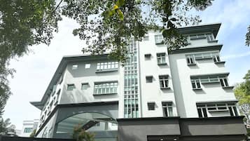 Un edificio a più piani dall'architettura moderna, caratterizzato da un ingresso di rilievo con facciata in vetro e un cartello con la scritta 'The Assembly Place'.