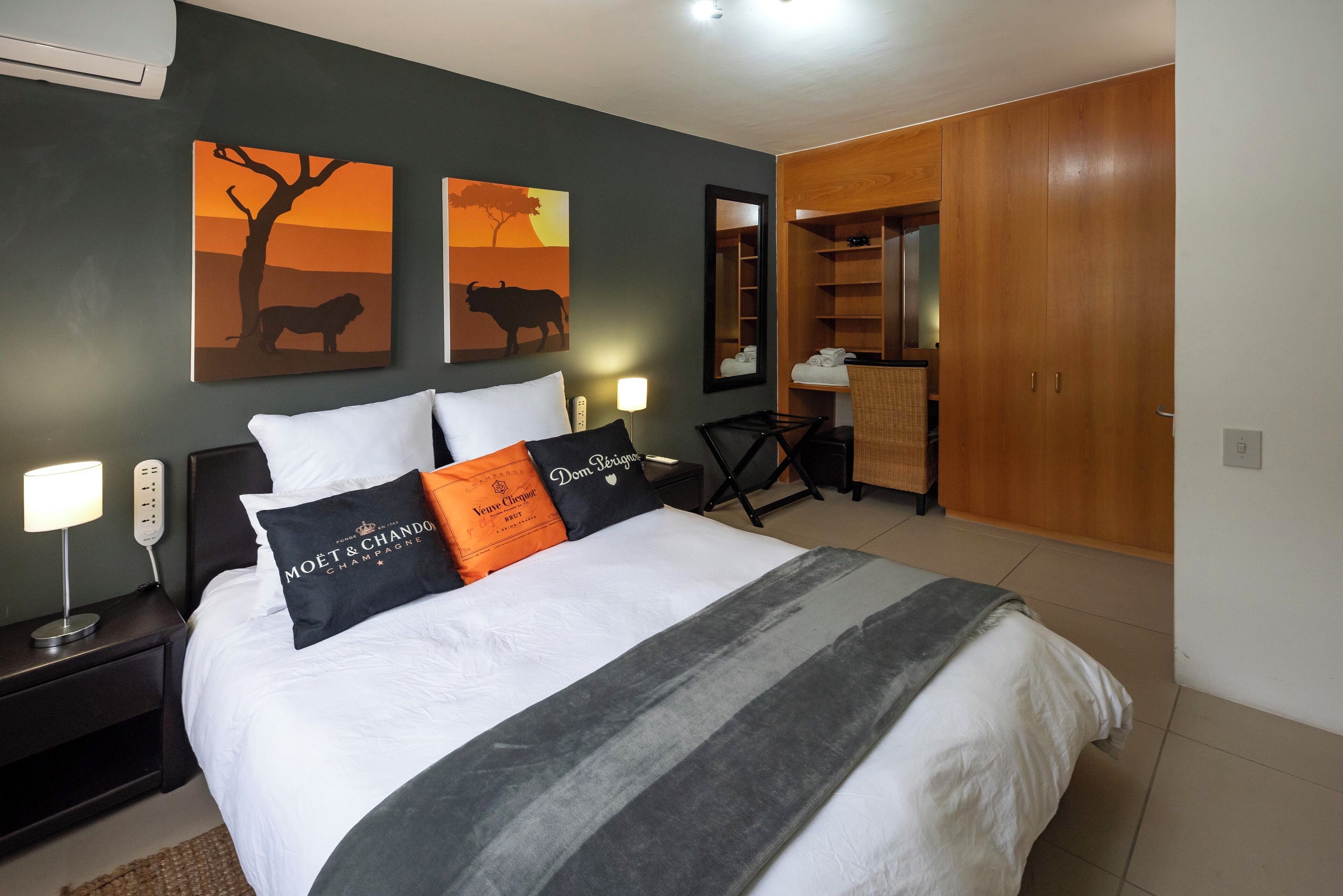 A hotel room with a bed, nightstands, a desk, and a wardrobe.