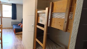 A room with a bunk bed, a sofa, and a window with curtains. - Paradiski closed to the slopes and shops vallandry (LANDRY)