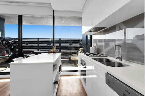 Enjoy a city view from the balcony, where the kitchen opens up to a spacious area with a large sink and oven.