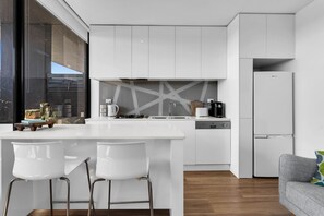 Enjoy cooking in the kitchen with a dishwasher and compact refrigerator, then relax in the adjacent living area with a sofa and large window.