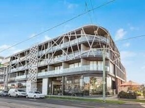 Experience the unique blend of glass and metal architecture in this modern building, featuring interconnected balconies and a central atrium.