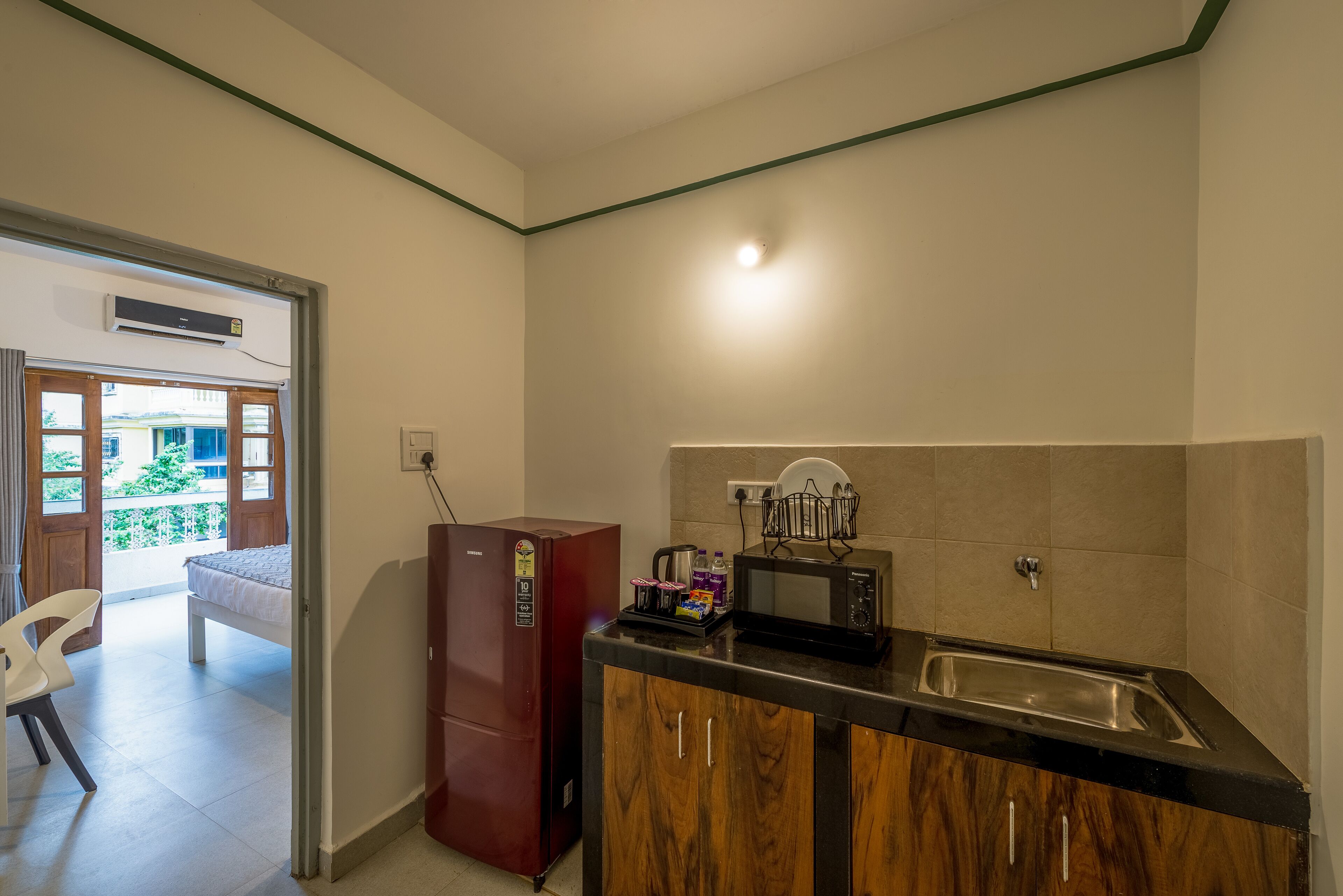 A compact kitchen with a refrigerator, microwave, sink, and a small countertop.