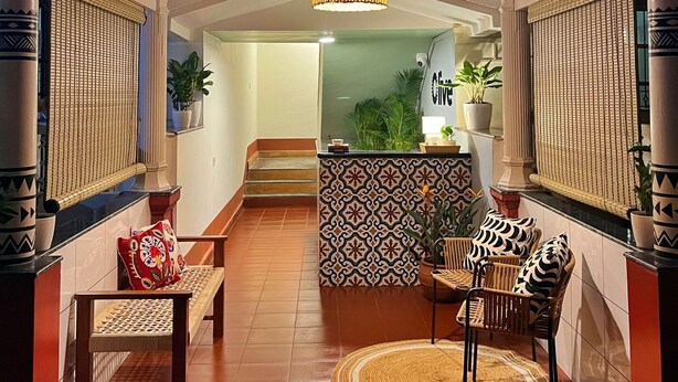 A hotel entrance with a 'live' sign, a reception desk, and a seating area with chairs and a rug. - Olive Hotel Calangute Niwasa by Embassy Group (Calangute)