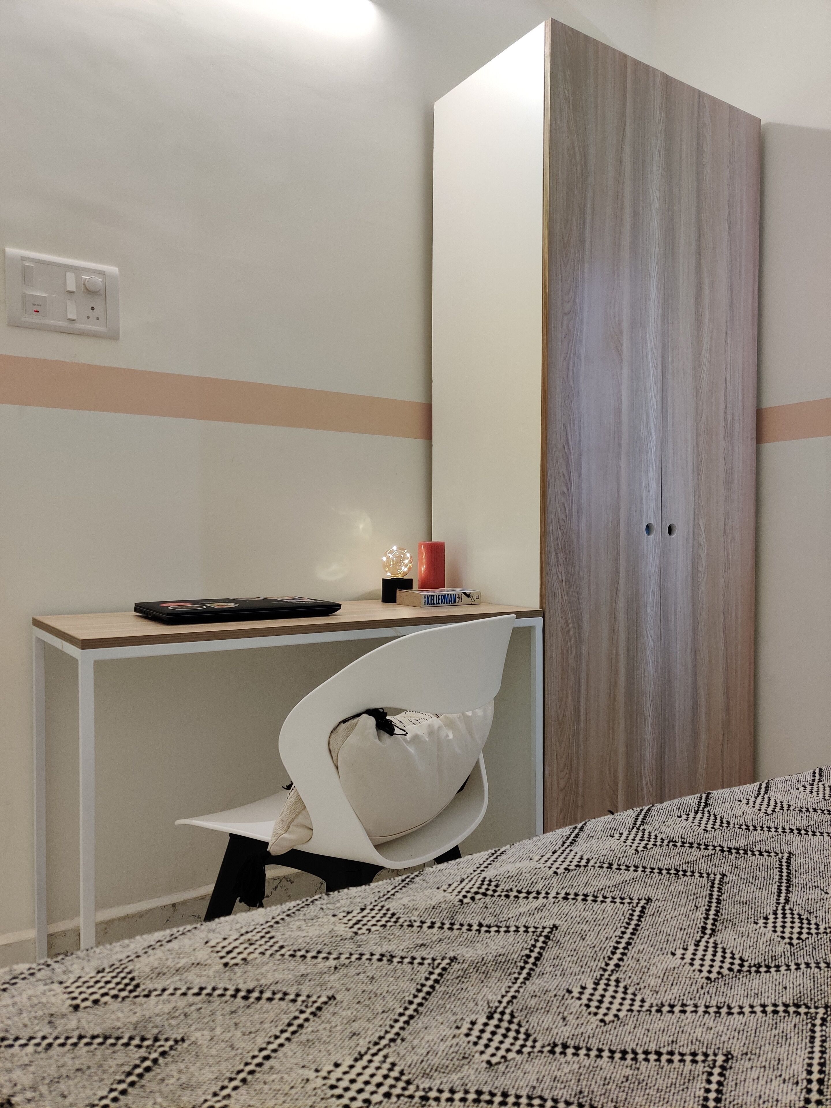 A bedroom with a bed, a desk, a chair, and a wardrobe.