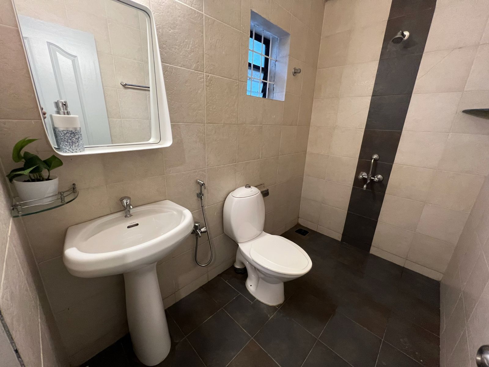 A bathroom with a pedestal sink, a toilet, and a shower.