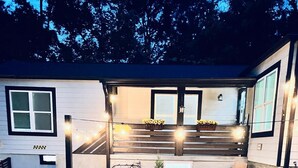 A modern house with a patio area, a small garden, and outdoor seating.