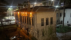 A historic building with a courtyard, featuring a central fountain and a small garden area.