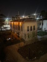 Un edificio histórico con un patio central, que presenta una fuente y un pequeño jardín.