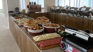 Montaje de bufé con diversos alimentos y una estación de parrilla.