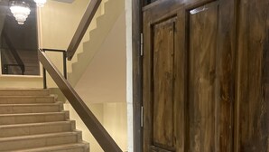 Una escalera con escalones de mármol y una puerta de madera.