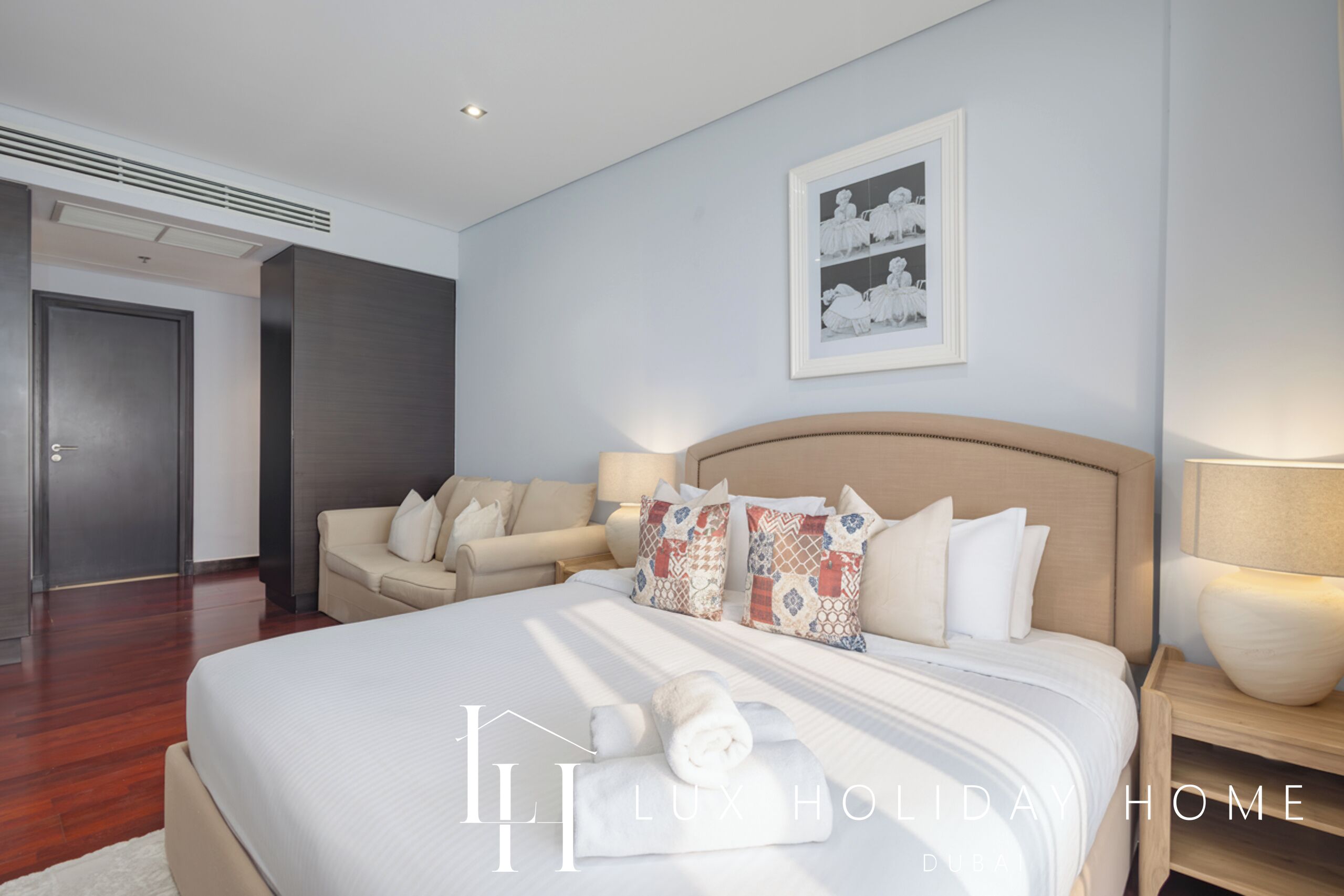 Una camera d'albergo moderna con un letto grande, una poltrona e un quadro appeso al muro.