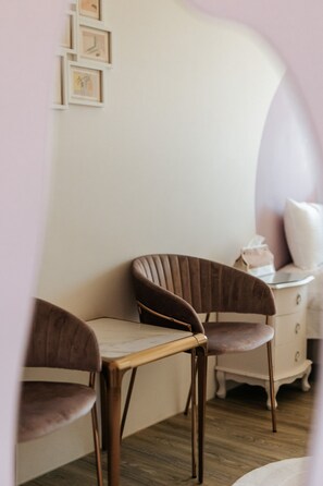 A room with a wooden table and two upholstered chairs, a white dresser, and a wall with framed pictures. - Fieldhome (Wujie)