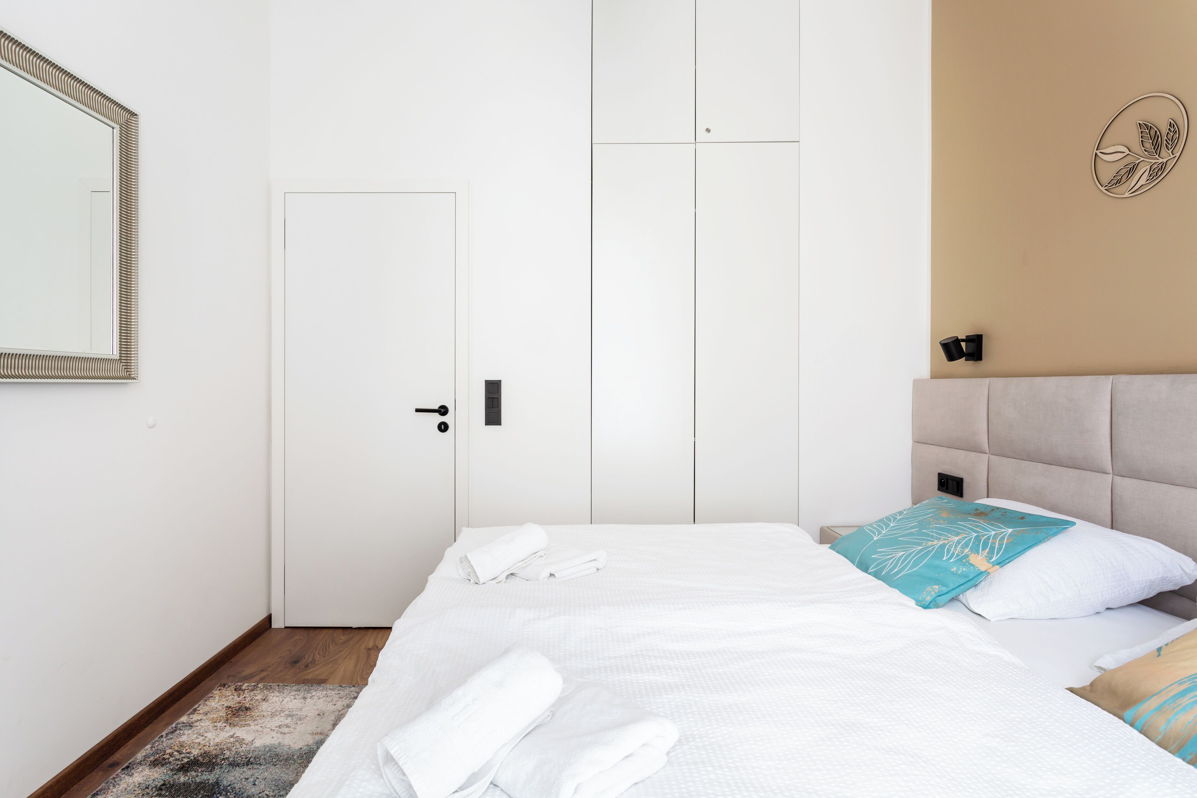 Ein Hotelzimmer mit Bett, Tür und einem Wandspiegel.