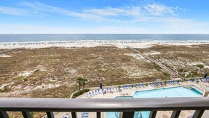 A beach resort with a pool, beach chairs, and a view of the ocean. - Beautiful Gulffront, Beachfront Phoenix VI Condo!! (Orange Beach)
