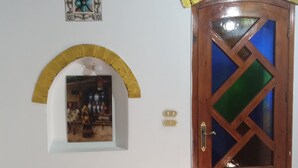 A wooden door with a glass panel, a small picture frame on the wall, and a tiled floor. - Golden Palace villa (Luxor)