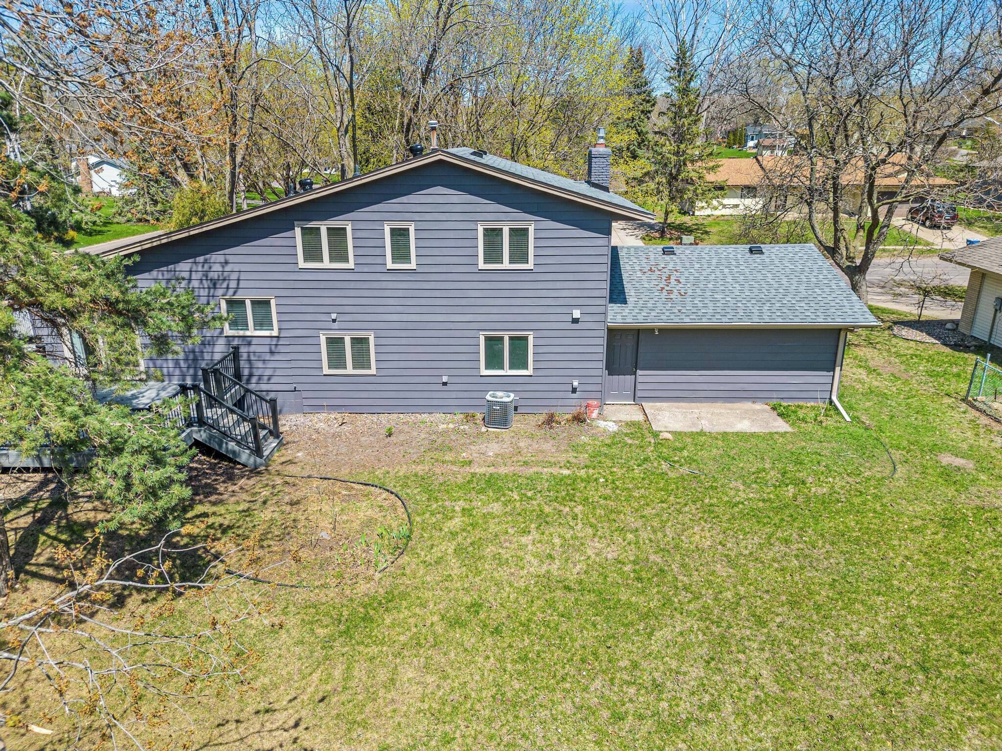 A two-story house with a front yard, a garage, and a staircase leading to the entrance.