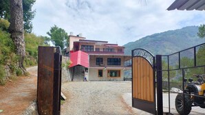 A gated entrance to a building with a gravel path leading to it. - Nature Roar Forest Resort (Nainital)