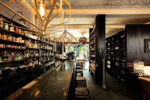 A bar with shelves of bottles, stools, and a bar counter.