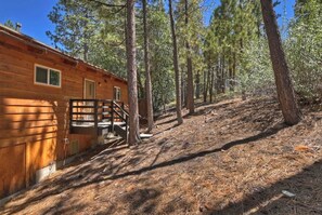 A wooden cabin with a staircase leading to a deck, surrounded by tall pine trees. - Eagle Peak Walk to Village & Lake Fire Pit (Big Bear Lake)