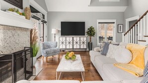 Un salon moderne avec une cheminée, un téléviseur à écran plat, un canapé et une table basse.