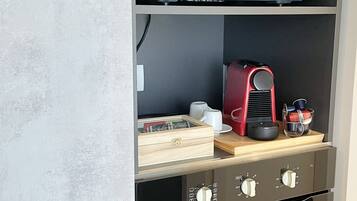 Une cuisine équipée d’un four à micro-ondes, d’une machine à café et d’un meuble à tiroirs.