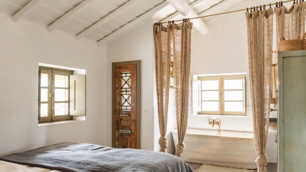 A bedroom with a bed, two windows, a door, and a bathtub. - Herdade da Saudade - La Casita (São Pedro Gafanhoeira)