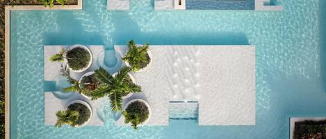An aerial view of a swimming pool with multiple planters and a sunken seating area.