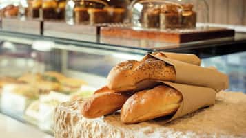 A display case with various baked goods and bread rolls.