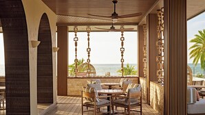 A wooden deck with a table and chairs, overlooking the ocean. - Crowne Plaza Fiji Nadi Bay Resort & Spa by IHG (Nadi)