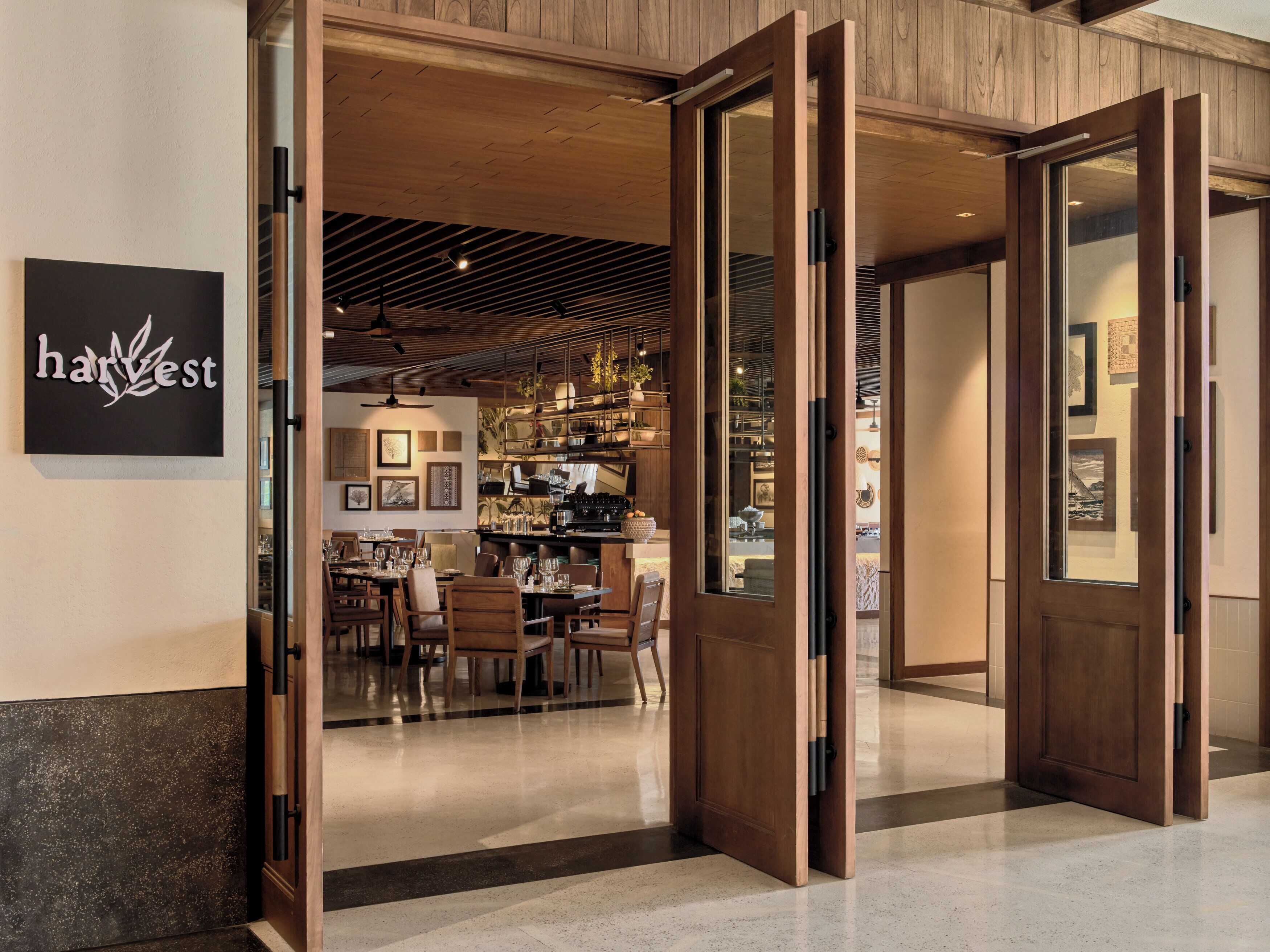A restaurant interior with wooden flooring, a bar area, and a dining section.