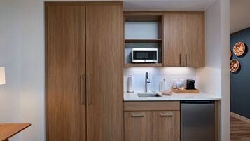 A modern kitchen with wooden cabinets, a microwave, a sink, and a dishwasher.