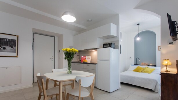 A modern apartment with a dining area, kitchen, and bedroom. - Blu di San Salvario by Wonderful Italy (Turin)