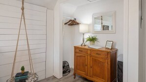 A room with a wooden cabinet, a hanging swing, a lamp, and a framed picture on the wall.