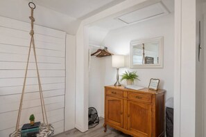 A room with a wooden cabinet, a hanging swing, a lamp, and a framed picture on the wall.