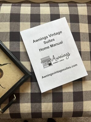 Un petit livret blanc intitulé « Guide d’utilisation des suites Awnings Vintage », avec une adresse de site web et un logo.