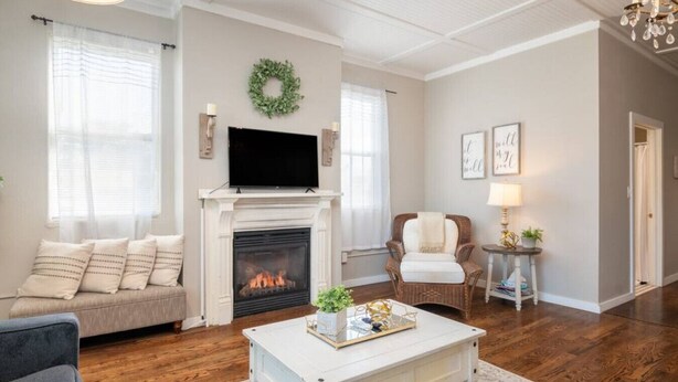 Una sala de estar con chimenea, un sofá, un sillón y una mesita de centro.