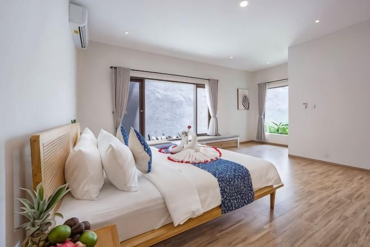 Un dormitorio moderno con una cama grande, una ventana y vistas al exterior.