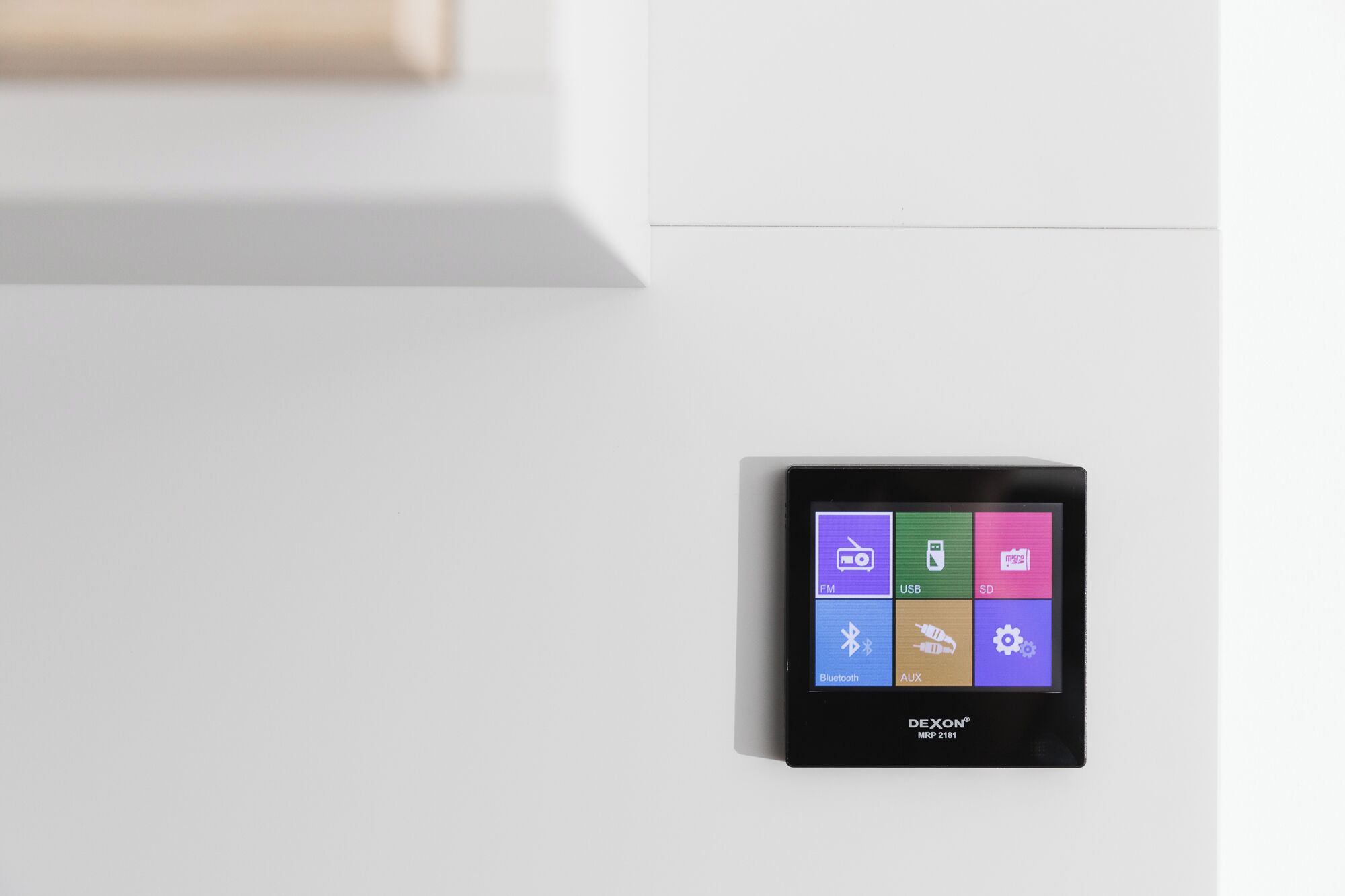 Un dispositivo negro con pantalla que muestra iconos para FM, USB, SD, Bluetooth y AUX.