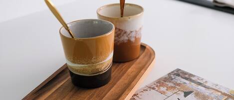 Two cups of coffee on a wooden tray with a magazine featuring 'Unique Places' on a table.