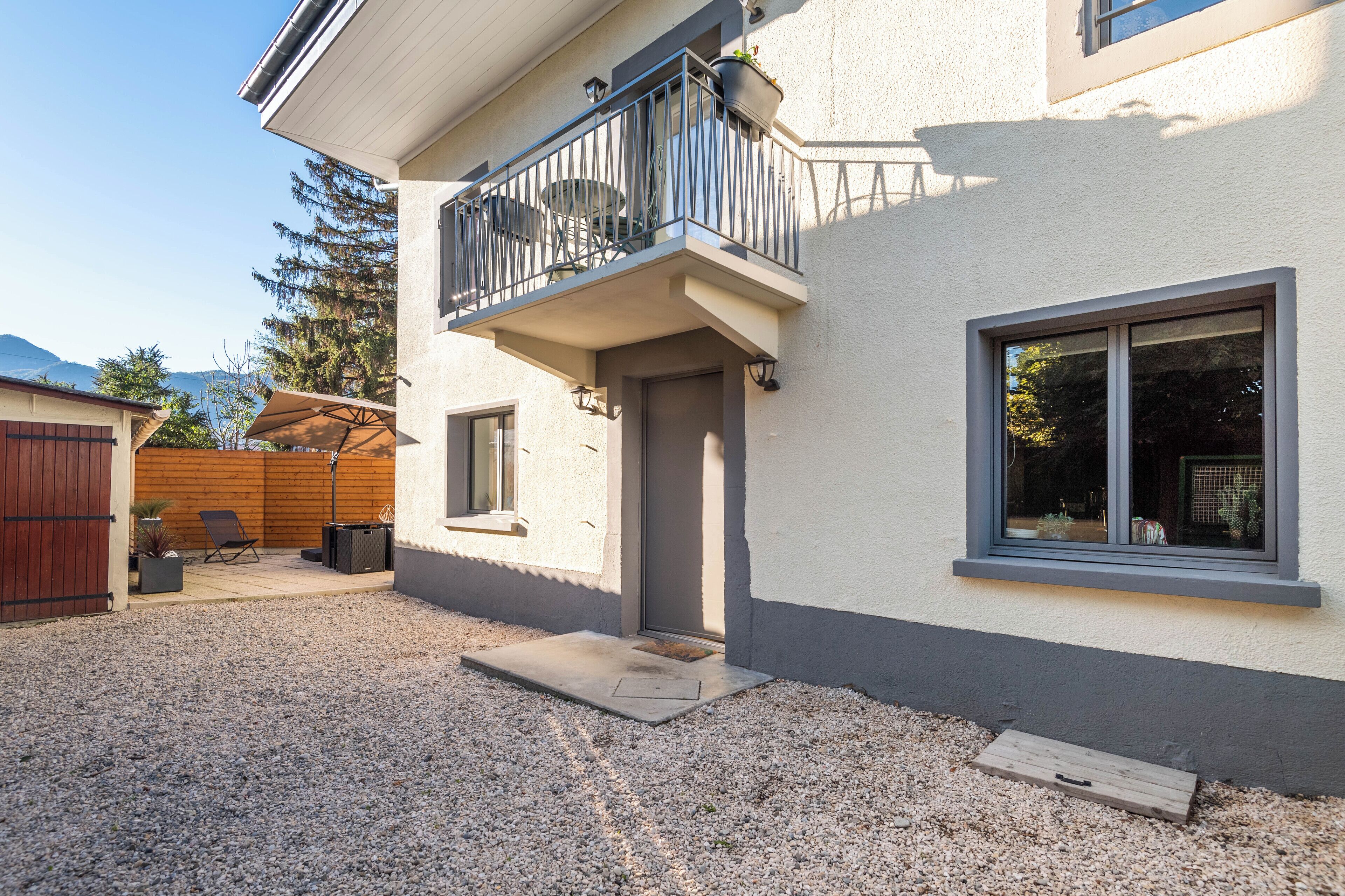 Une maison à deux étages avec un balcon, une porte d’entrée et une fenêtre.