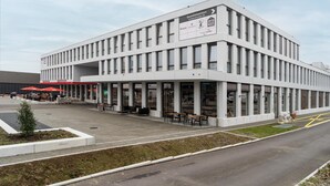 A modern building with a ground-level cafe and upper-level retail space.