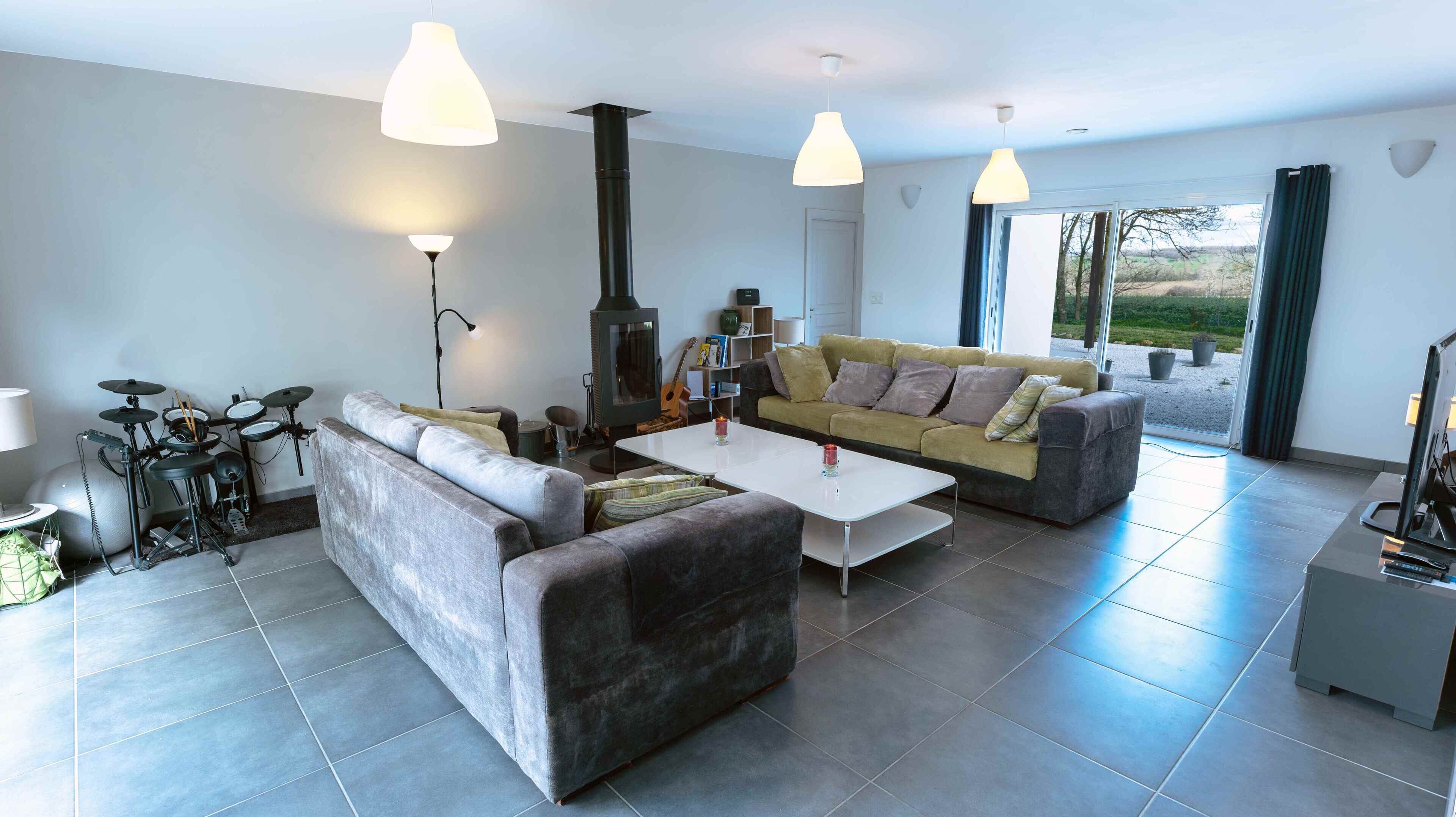 Un salon moderne avec un canapé, une table basse et une cheminée.