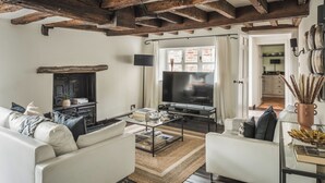 A living room with a sofa, armchair, coffee table, TV, and fireplace. - Lovely 3-bed House in West Malling, Kent (West Malling)